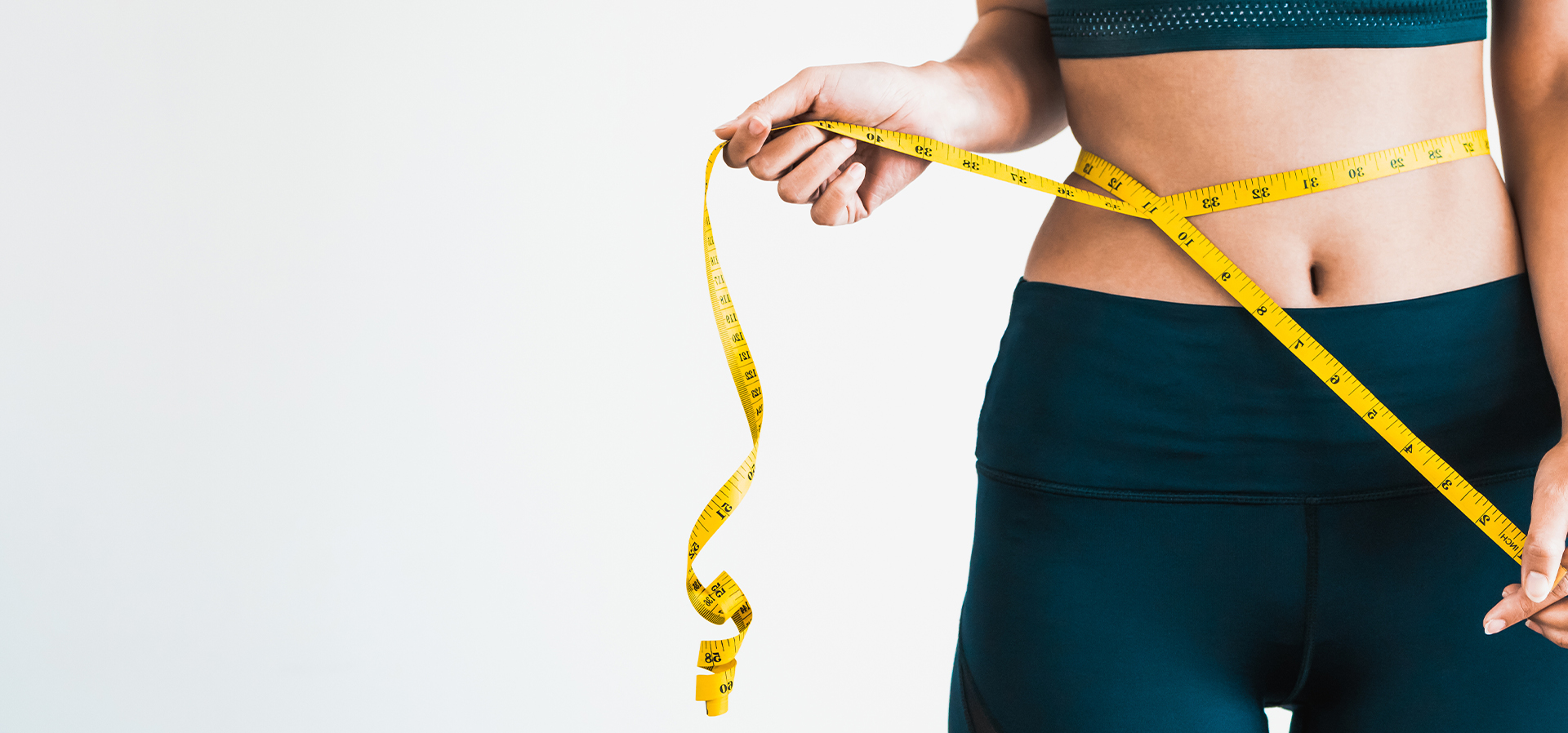 Woman measuring her waistline